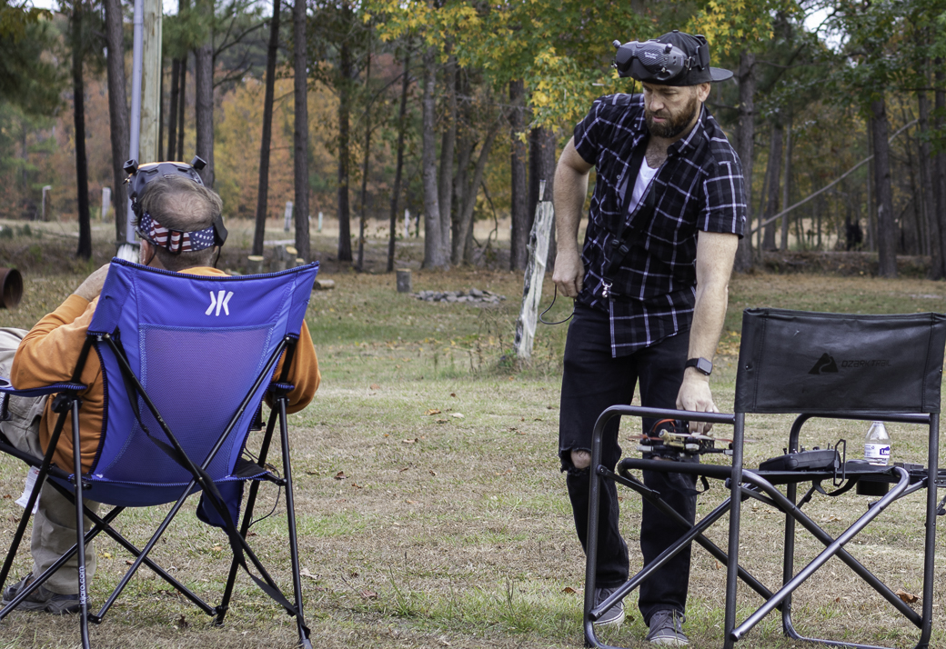 FPV pilots talking and working with equipment at a flying location